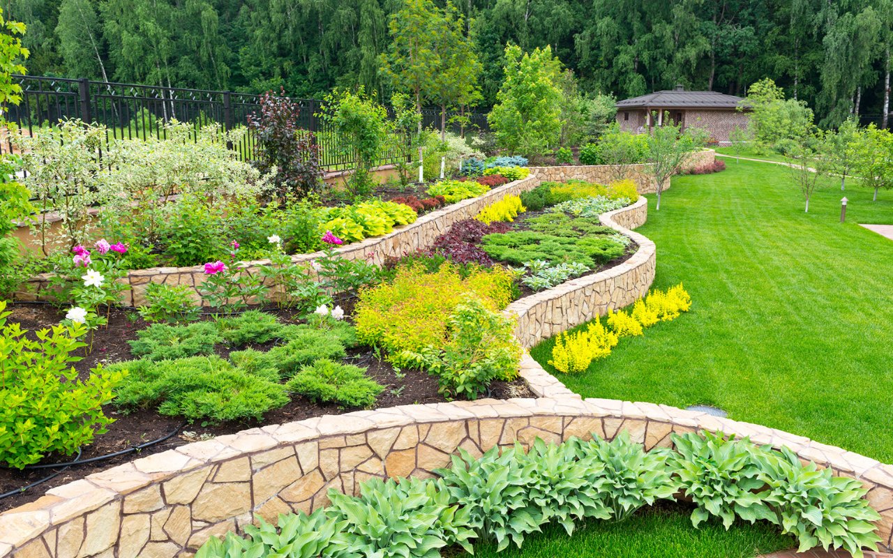 retainign wall with many plants in a big yard - professional landscaping utah
